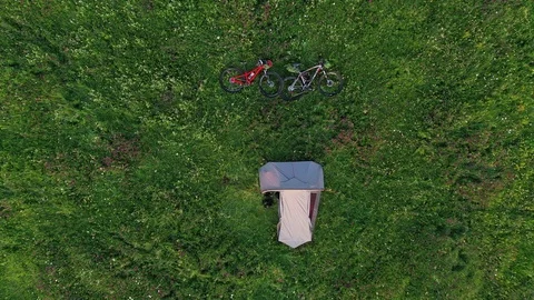 Drone video with two mountain bicycles and a tent on a mountain meadow Video stock 113205262