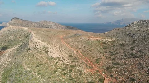 Drone video of walking path in the mountains with sea view in Greece Stock Footage 128106530