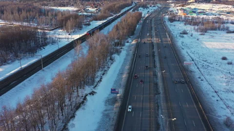 Drone Video - Winter Highway with shadows, dirty snow, moving cars and a train Stock Footage 173033127
