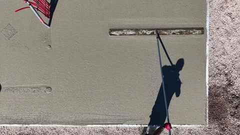 Drone video of worker leveling concrete slab with long trowel Aerial video Stock Footage 310123094