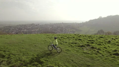 Drone video of a young boy riding his bike in a field. Stock Footage 239916873
