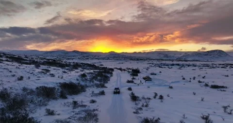Drone view of a 4x4 approaching a snowy parking area in Heiðmörk, Iceland, with 库存影片 340999799