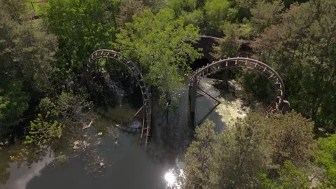Drone view of an abandoned roller coaster flooded in forest Stock Footage 336901754