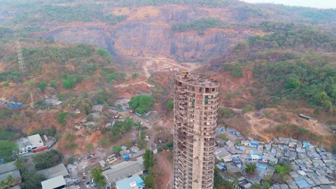 Drone view abandoned skyscraper stand among scattered homes Stock Footage 304500641