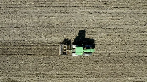 Drone view from above of a tractor drawing its shadow on the field Stock-Footage 263713693