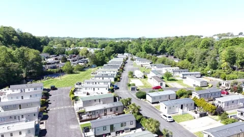Drone view across caravan park set within natural valley greenery and open sky Vídeo Stock 337294196