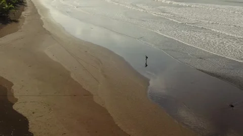 Drone view of Alone person walking on a coastline. Stock Footage 269930682
