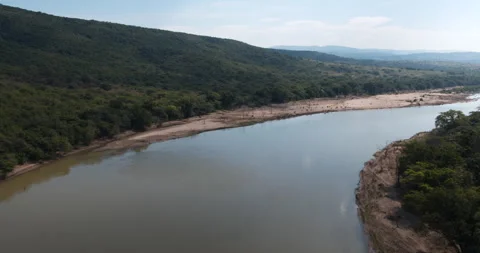A drone view along a river that separates around a small island. Stock Footage 243002765