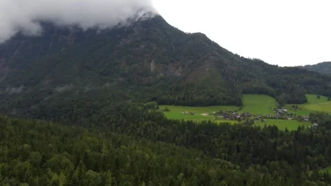 Drone view, alpine peaks in the clouds, green meadows and forests. Stock Footage 290078447
