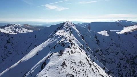 Drone View of Alpinist on Snow Covered Mountain Ridge During Winter Stock Footage 338988568