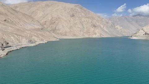 Drone view of arid mountain valley and clear blue lake in Xinjiang China Stock Footage 337646117
