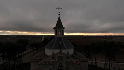 Drone view in ascending flight towards the bell tower of a small church surro Stock Footage 261383494