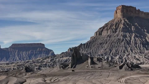 Drone View of ATV Moving Under Sandstone Rock Formation and Factory Butte on Stock Footage 346676952
