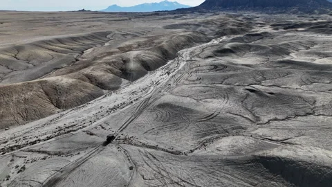 Drone View of ATV Vehicle Moving in Barren Desert Landscape Under Factory Stock Footage 346470754