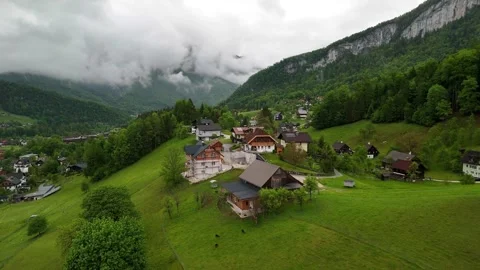 Drone View of Austrian Hilltop Homes and Dramatic Alpine Cliffs Stock Footage 325592065