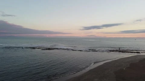 Drone view of the beach from above as the sun goes down Stock Footage 227440919