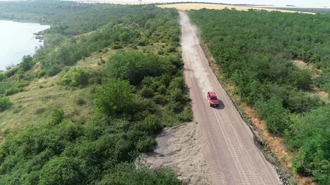 Drone view big red pickup is driving very fast along a dusty road Stock Footage 103426270