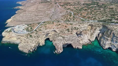 Drone view of Blue Grotto cliffs, sea arch, and boats over clear water Stock Footage 337002110