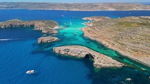 Drone view of Blue Lagoon Malta with boats by Cominotto cliffs in clear water Video stock 340589808