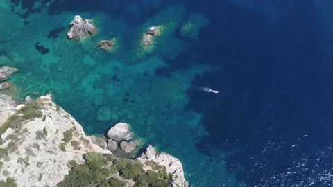 Drone view of boat drifting along rocky Gyali Beach coast Stock Footage 313889968