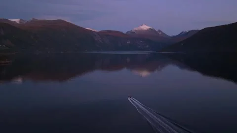 Drone view of boat racing through calm fjord at golden hour, Norway Stock Footage 320429914