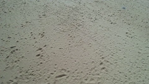 Drone view from bottom to top sandy beach frozen sea ocean bay on a sunny day Видео 186094860