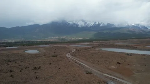 Drone view of braided river plain below cloudy mountains in Xinjiang China Stock Footage 337767281