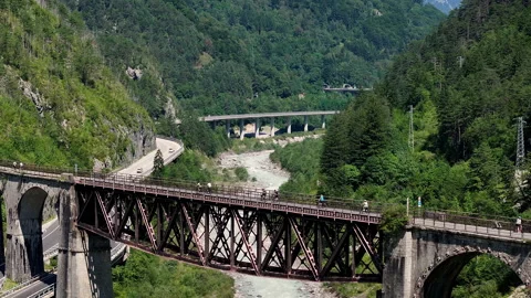 Drone view of a bridge in the mountains with cyclists Stock Footage 263384718