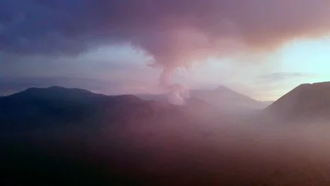 Drone view of the Bromo volcano at dusk, with smoke and clouds. Java, Stock Footage 101157604