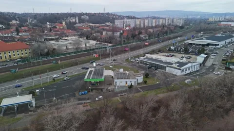 Drone view of Budafok streets with buildings, traffic, train tracks, and clouds Stock Footage 336468603
