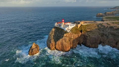 Drone view of Cabo de Sao Vicente lighthouse at sunrise around the cliff edge Stock-Footage 344288544