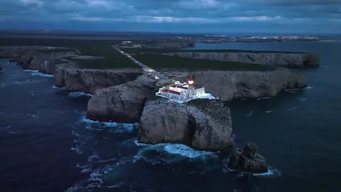 Drone view of Cabo de Sao Vicente Lighthouse at night by the cliff fortress Stock Footage 344956673