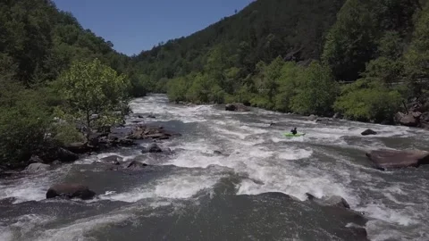 Drone View of Canoeist Paddling Through Rocky River Stock Footage 314692206