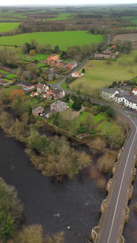 Drone view captures Croft-on-Tees scene shows houses, river, and bridge Video stock 335830805