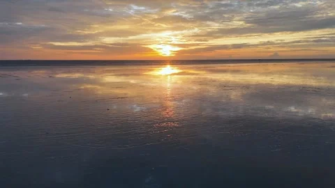 Drone view captures muddy coastal terrain with sunset reflections 스톡 동영상 332213767