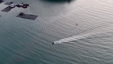 Drone view captures parasailing activity near kelong fish farm at sea Stock Footage 332202248