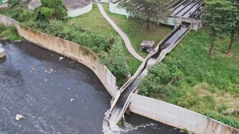 Drone view captures wastewater being discharged into a large drainage canal.. 스톡 동영상 329313126