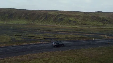 Drone view of a car driving through moss-covered plains in Iceland. Scenic road Stock Footage 334321201
