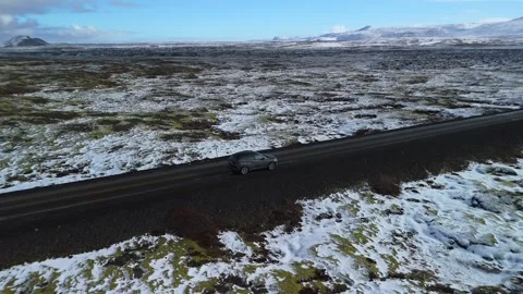 Drone view of a car driving through moss-covered plains in Iceland. Scenic road Stock Footage 334326052