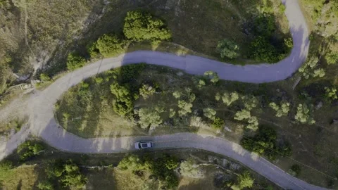 Drone view of a car driving on winding roads in nature. Stock Footage 247184405