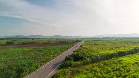 Drone View of Car fast Driving on Countryside Road Through Tropical Fields with Stock Footage 316461117