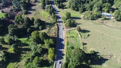 Drone view of cars driving around curve on country road Video stock 77325853