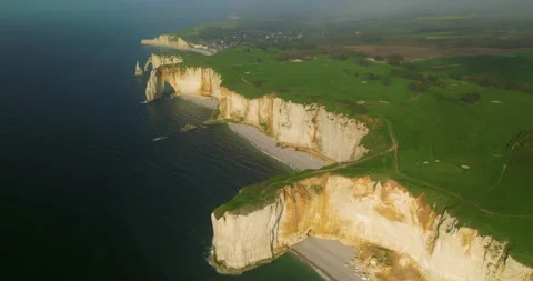 Drone view of the chalk cliffs on the seashore. People walk along the green Stock Footage 241363570