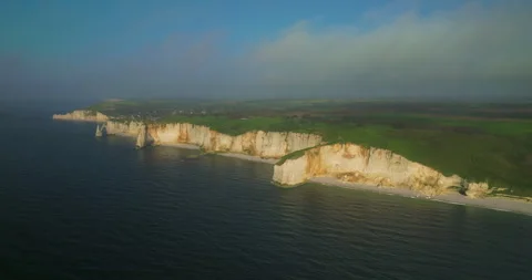 Drone view of the chalk cliffs on the seashore. People walk along the green Stock-Footage 241574898