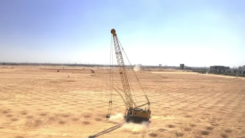 Drone view circling a lattice boom crane on sandy ground 库存影片 346429569