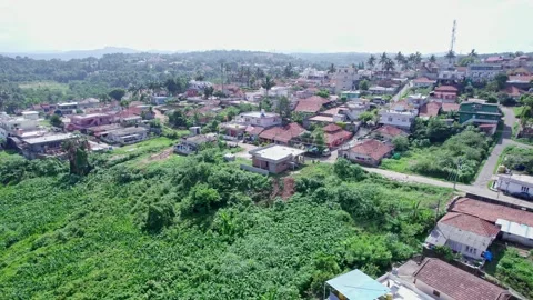 A drone view of city amidst lush mountains shows old rural homes buildings .. Stock-Footage 344411475