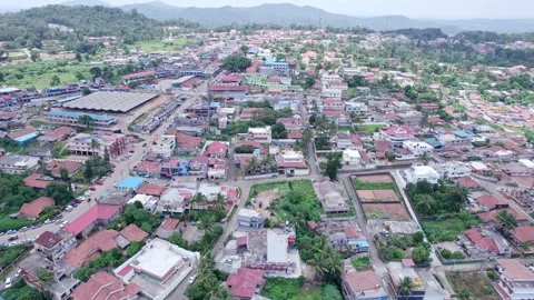 A drone view of city amidst lush mountains shows old rural homes buildings .. Stock-Footage 344411792