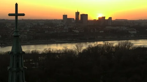 Drone view of city during sunset from behind church cross Stock Footage 89633311