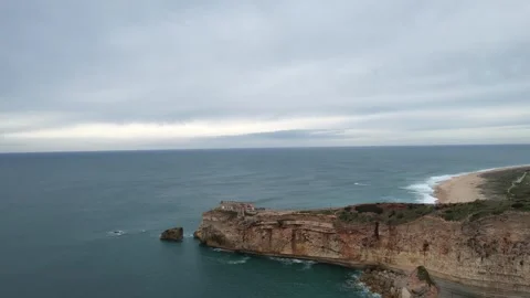 Drone view of cliff and lighthouse in Nazare, Portugal Stock Footage 265442597