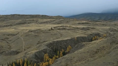 Drone view: cloudy weather in mountains terrain with foggy peaks in background Stock Footage 156468206